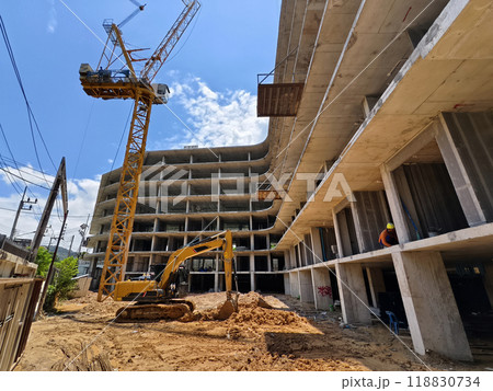 Excavator loads ground into a dump truck at a construction site 118830734