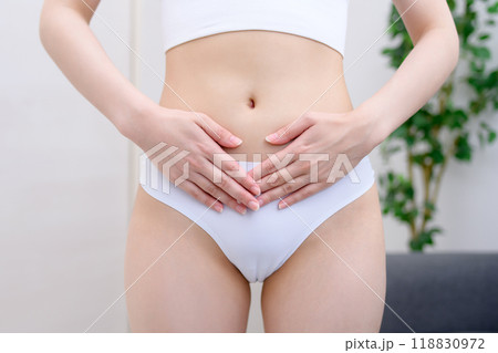女性ならではの病気　悩み　診断　下腹部　PMS　両手でお腹をおさえる女性 118830972
