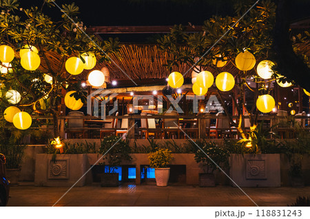 Yellow glowing Chinese lanterns decorate the exterior of cafe in Vietnam in Asia Yellow glowing Chinese lanterns decorate the exterior of cafe in Vietnam in Asia 118831243