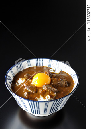 月見ビーフカレー丼を黒背景で撮影 118832710