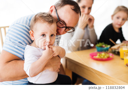 Parents with two children eating a tasty, healthy breakfast in the kitchen. Happy family moment. Parents with two children eating a tasty, healthy breakfast in the kitchen. Happy family moment. 118832804