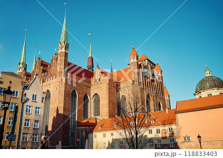St Mary Basilica in Gdansk, Poland. Historical religious building facade. Towering Gothic architecture with spires, and clock against blue sky 118833403