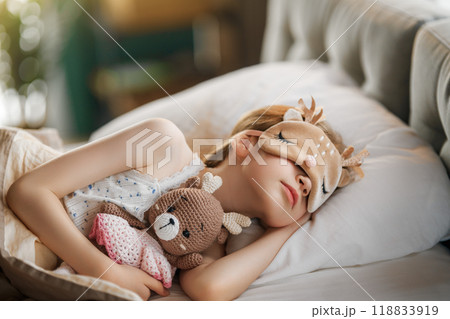 child is sleeping in the bed 118833919