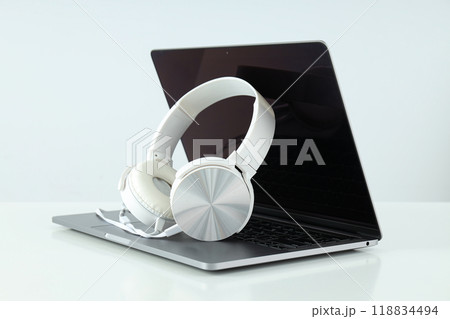 Big headphones, on a table with a laptop. Big headphones, on a table with a laptop. 118834494