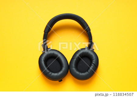 Over-ear, black headphones, on a dark background. 118834507