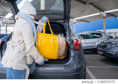 Woman uploading Groceries into Car Woman uploading Groceries into Car 118835573