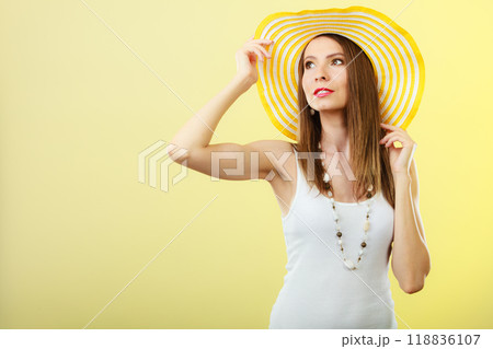 Woman in big yellow summer hat. 118836107