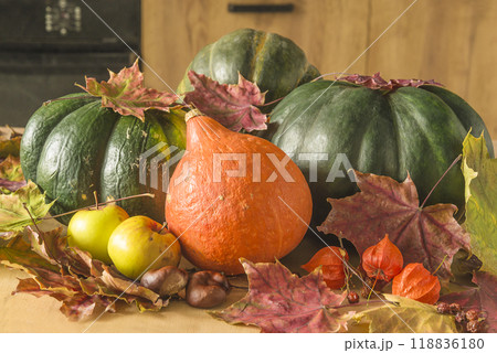 Various pumpinks, apples and dry maple leaves on wooden background Various pumpinks, apples and dry maple leaves on wooden background 118836180