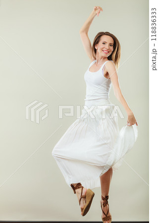Woman in summer white dress jumping Woman in summer white dress jumping 118836333