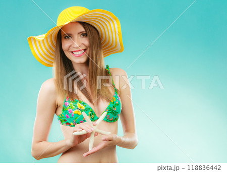 Woman in yellow hat holding white shell 118836442