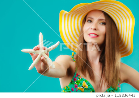 Woman in yellow hat holding white shell 118836443