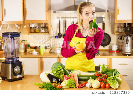 Funny woman taking bite of bell pepper 118837380