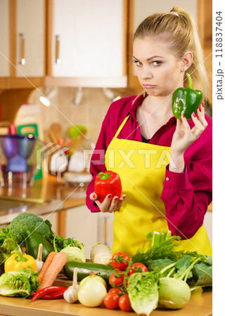 Woman holding bell peppers paprika thinking Woman holding bell peppers paprika thinking 118837404