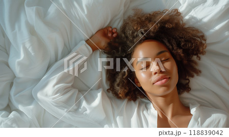 Smiling african american woman sleeping on white bed with copy space Smiling african american woman sleeping on white bed with copy space 118839042