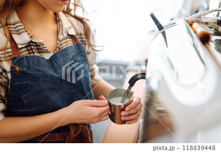 An experienced female bartender prepares a hot drink. Takeaway food. Professional coffee making. 118839448