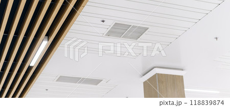 Ceiling mounted cassette type air conditioner and modern lamp light on a white ceiling. duct air conditioner for office or home Ceiling mounted cassette type air conditioner and modern lamp light on a white ceiling. duct air conditioner for office or home 118839874