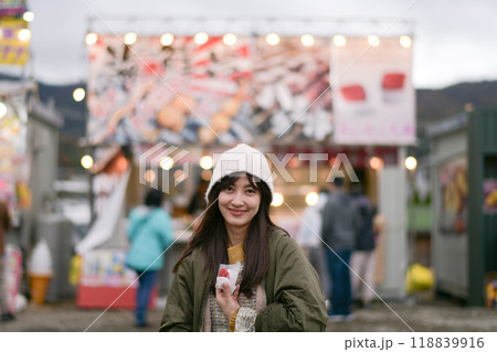 Japanese traveler enjoys a tasty strawberry treat in Tokyo during the sakura festival. A happy portrait capturing the essence of March in Japan. 118839916