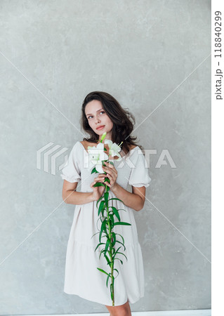 brunette woman in dress holding flowers brunette woman in dress holding flowers 118840299