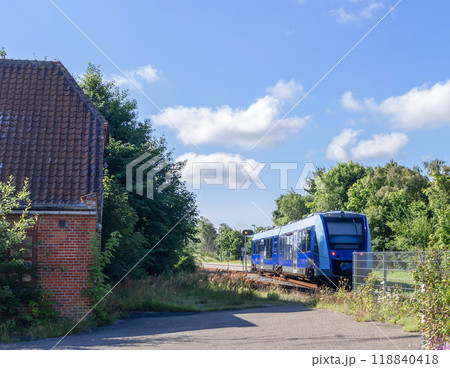 A Blue train rides through the countryside. 118840418