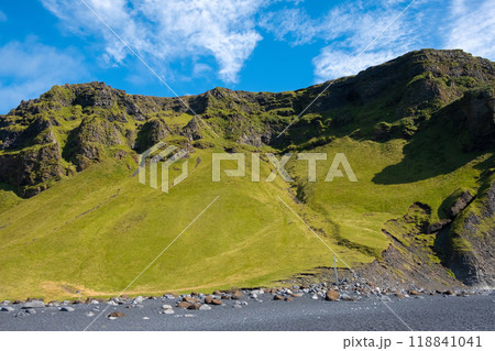 Mountain ridge covered with green grass against blue sky on a sunny day. 118841041