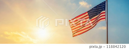Waving American flag set against a dramatic sky background. Represents freedom and patriotism. 118842120