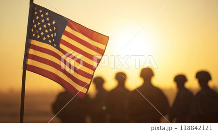 Silhouette of American flag and military unit at sunset. A Veterans Day commemoration. 118842121