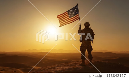 Soldier standing proudly with the American flag at sunrise, representing strength and honor on Veterans Day. 118842127