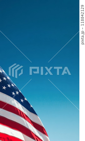American flag waving proudly against a clear blue backdrop, symbolizing national values. 118842129