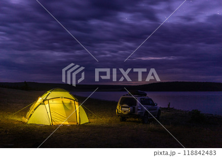Tourist camping at a lake coast at night under cloudy sky. Khuvsgul lake, Mongolia 118842483