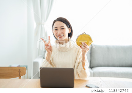 財布を持つ女性　笑顔　ピース 118842745