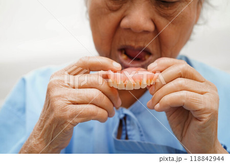 Doctor holding teeth denture in hand for dentist studying about dentistry. 118842944