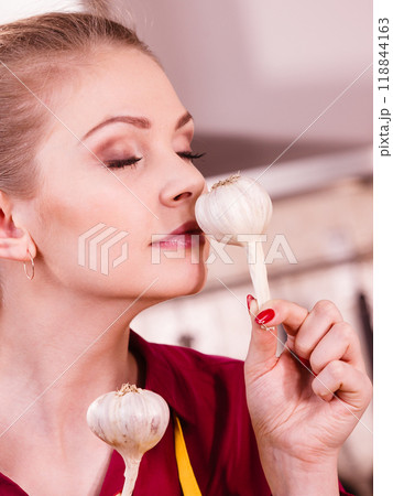 Woman holding and smelling garlic Woman holding and smelling garlic 118844163