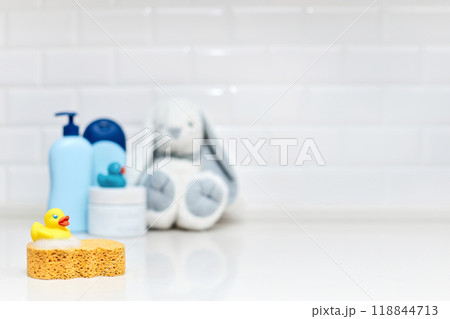 Yellow rubber duck, soap, bath foam on bath background, baby bath accessories Yellow rubber duck, soap, bath foam on bath background, baby bath accessories 118844713