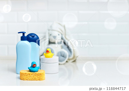 Yellow rubber duck, soap, bath foam on bath background, children bath accessories. copy space Yellow rubber duck, soap, bath foam on bath background, children bath accessories. copy space 118844717