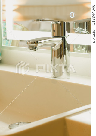 A shiny silver metal faucet on the sink. 118844946