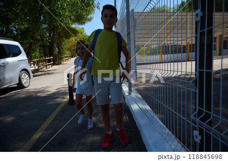 Children walking to school on a sunny day with backpacks 118845698