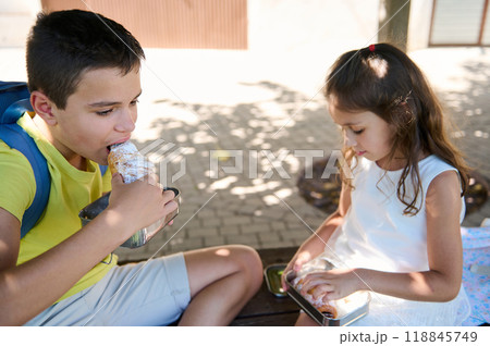 Children enjoying a snack outdoors on a sunny day 118845749