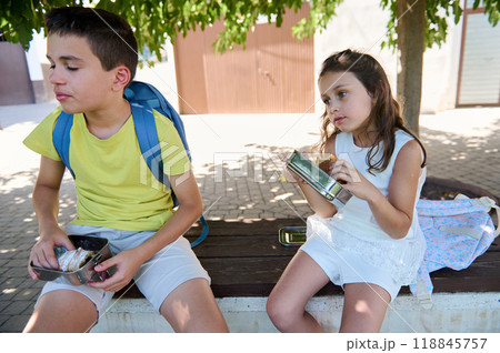 Children enjoying a snack break outdoors on a sunny day Children enjoying a snack break outdoors on a sunny day 118845757
