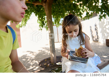 Children enjoying a healthy lunch outdoors under a tree Children enjoying a healthy lunch outdoors under a tree 118845764