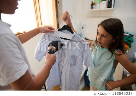 Young girl observes while shirt is steamed at home 118846037