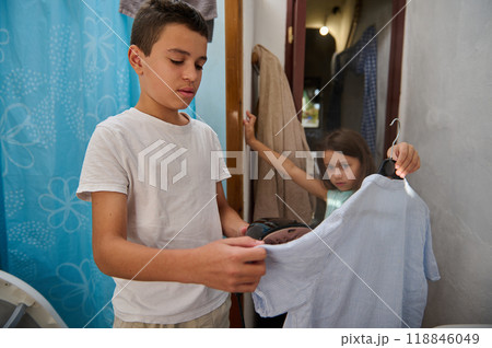 Siblings selecting clothes in a home setting with focus 118846049