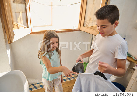 Brother and sister enjoying laundry chores together at home Brother and sister enjoying laundry chores together at home 118846072