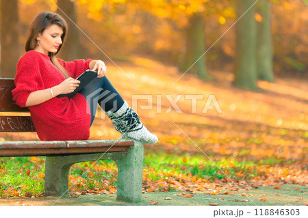 Woman on bench in park with tablet. Woman on bench in park with tablet. 118846303