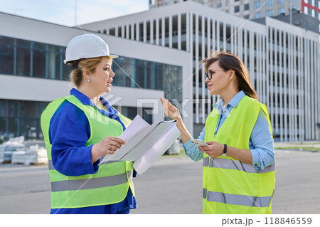 Two confident women talking working on construction of residential office building 118846559
