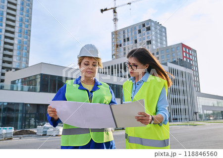 Two confident women talking working on construction of residential office building 118846560
