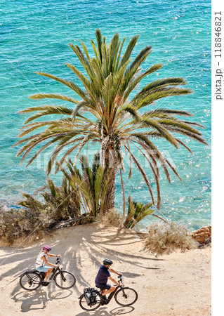 Couple moving on bicycles along Mediterranean Sea 118846821