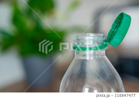 Stationary plastic cap on a PET bottle. The new design means the cap remains attached to the bottle after opening, making the entire package easier to collect and recycle 118847477