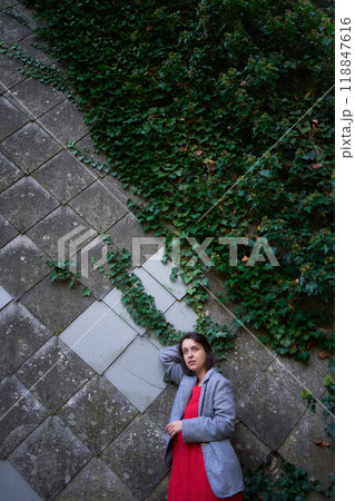 30-year-old medium-sized woman in a red muslin dress in an autumn garden 30-year-old medium-sized woman in a red muslin dress in an autumn garden 118847616