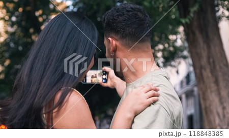 Happy couple taking selfie via mobile phone in city Happy couple taking selfie via mobile phone in city 118848385