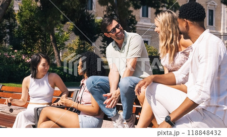 Happy diverse friends talking on bench in city park 118848432